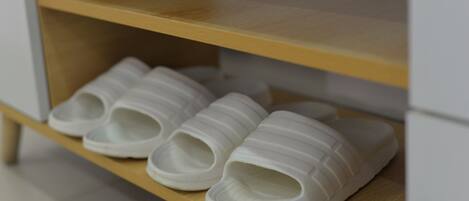 A wooden shelf with white slippers.