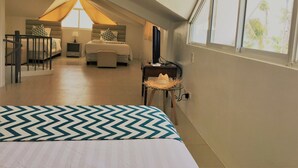 Un dormitorio con cama, escritorio y ventana.