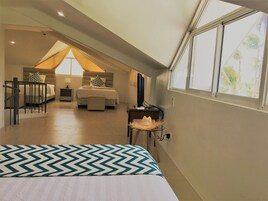 Un dormitorio con cama, escritorio y ventana.