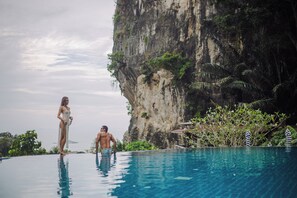 A pool with a view of a cliff and lush greenery. - Railay Phutawan Resort (Krabi)