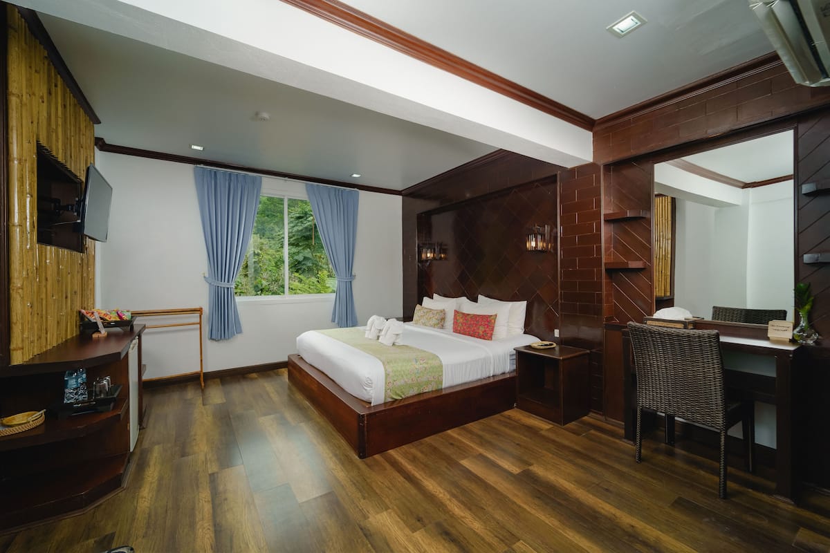 A bedroom with a wooden bed, a desk, and a chair.