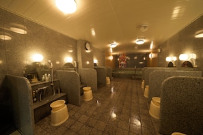 A public restroom with granite walls, multiple sinks, and mirrors.