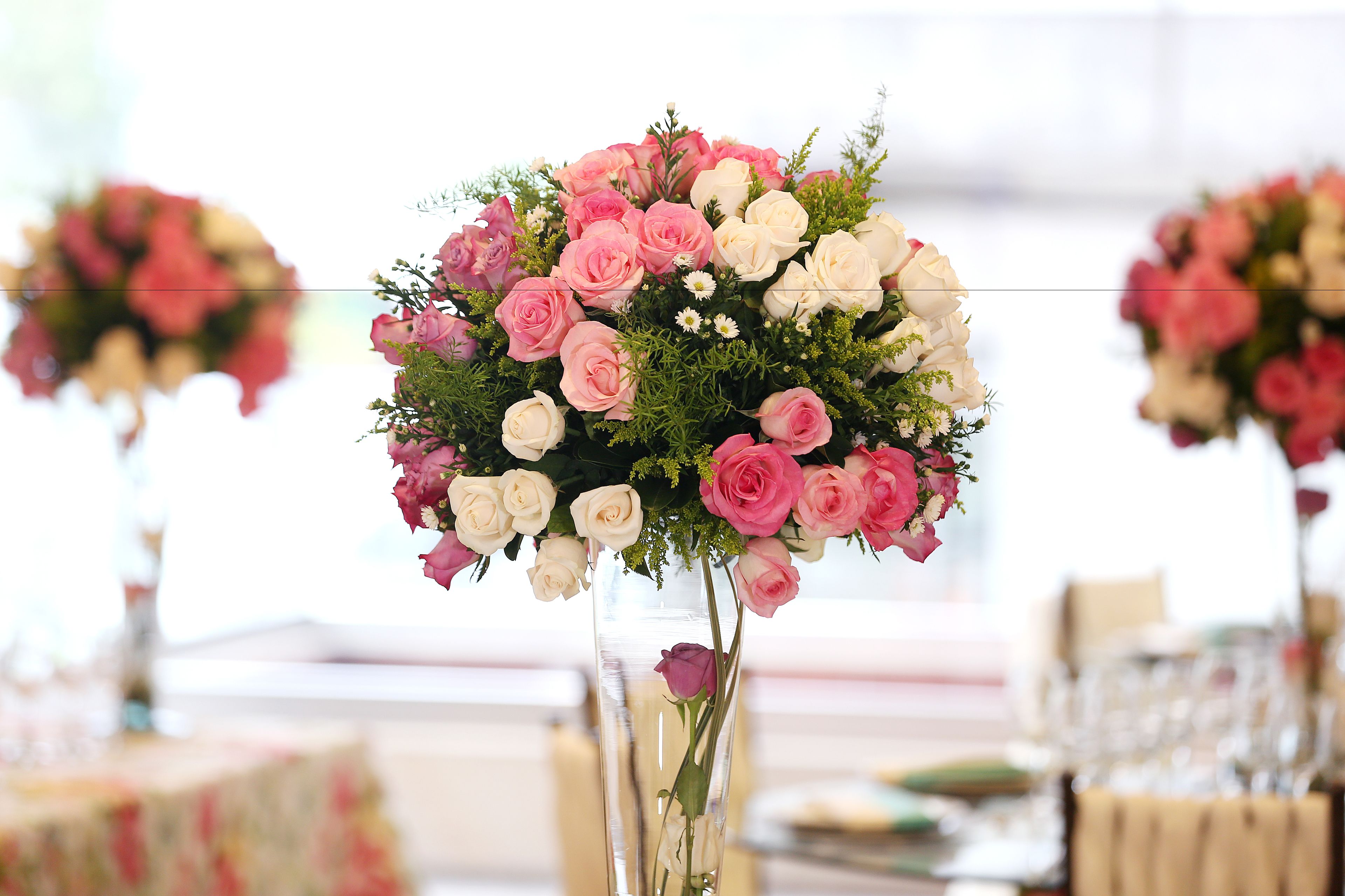 A bouquet of pink and white roses in a clear vase.