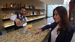 Una zona de bar con un barman preparando una bebida.