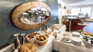 Montaje de bufé con diferentes alimentos y un espejo que refleja el comedor.
