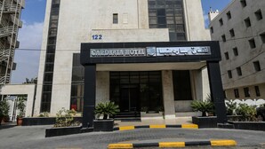 A modern building with a large entrance, numbered 122, and a sign in a foreign language. - Gardenia Hotel (Amman)