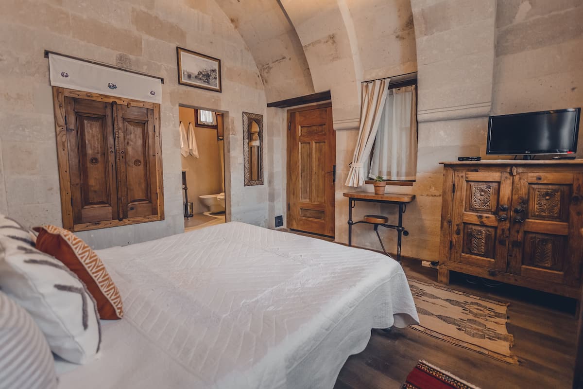 Una camera da letto con un letto grande, un armadio in legno e una televisione su un mobile in legno.