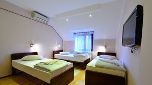 A room with two single beds, a TV mounted on the wall, and an air conditioning unit on the ceiling. - Prenociste Stojic Novi Sad (Novi Sad)