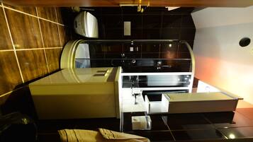 A compact kitchen with a built-in stove, a microwave, and a sink.
