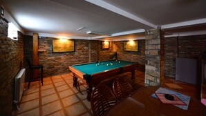 A pool table in a room with stone walls and a tiled floor. - Prenociste Stojic Novi Sad (Novi Sad)