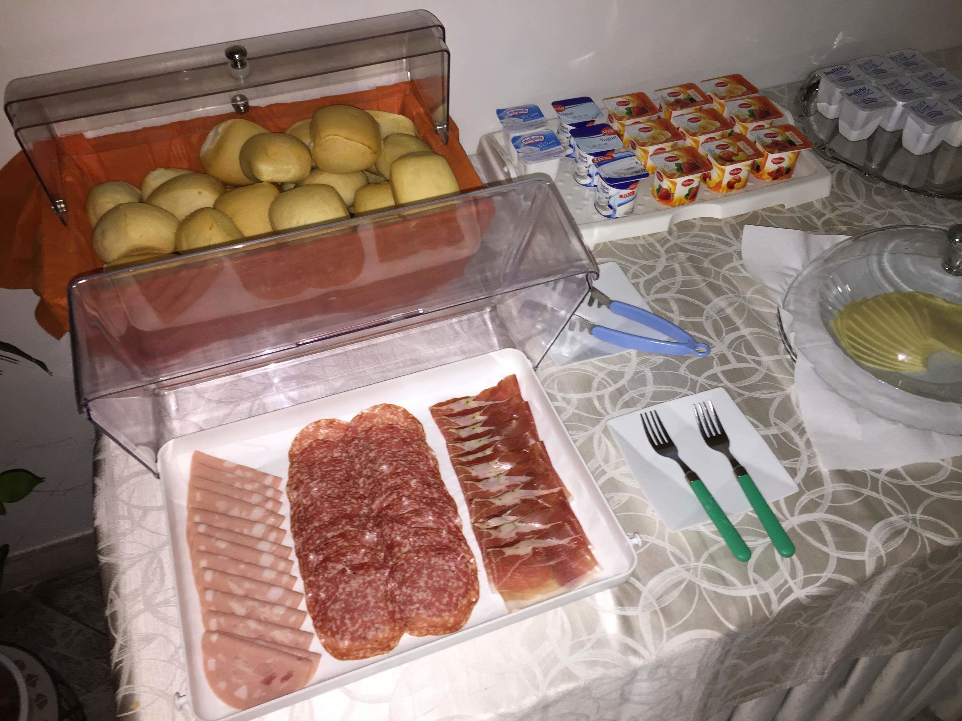 Een buffet met diverse soorten eten, zoals brood, yoghurt en vlees.