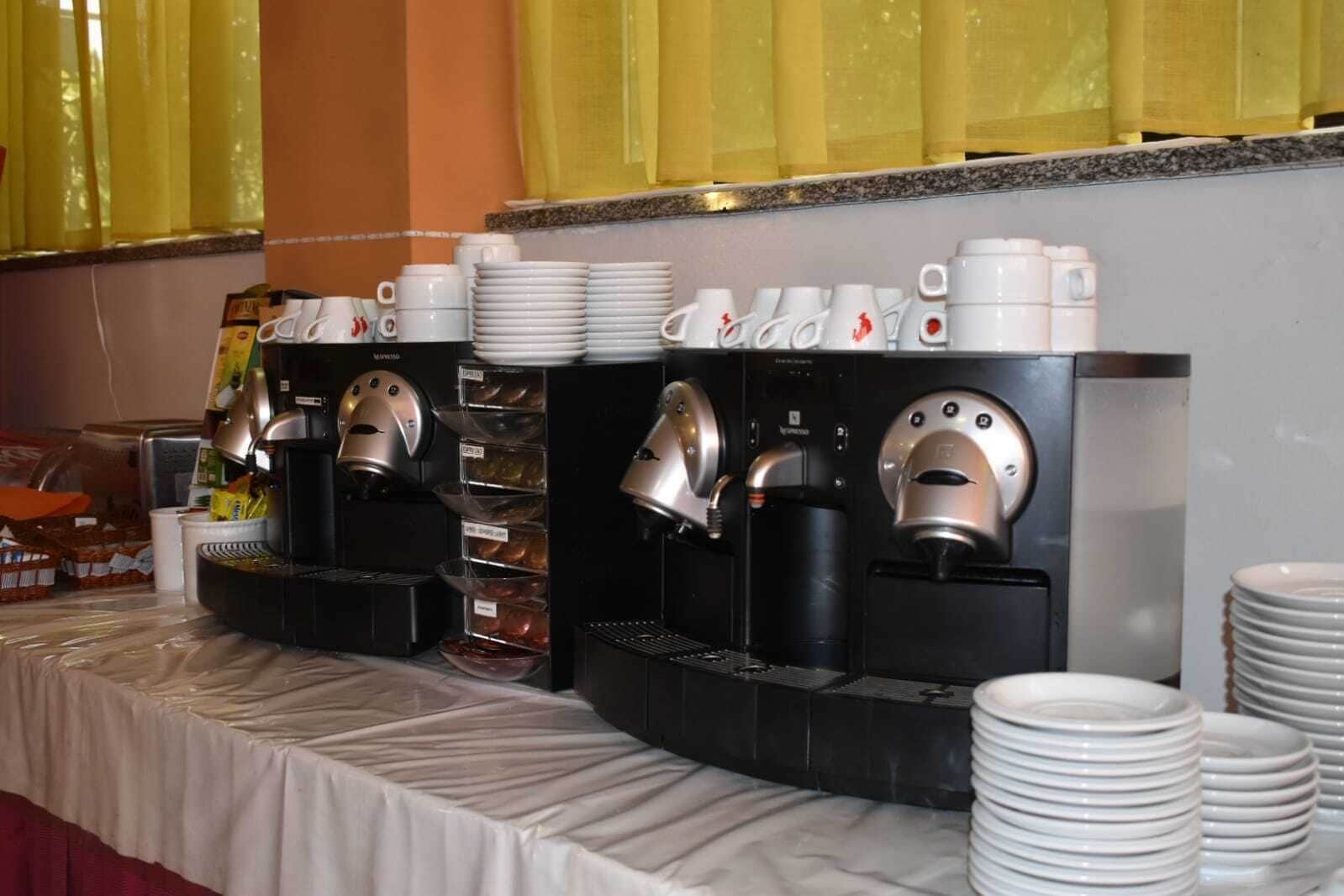 Ein reichhaltiges Buffet mit verschiedenen Kaffeemaschinen und Stapeln weißer Teller.