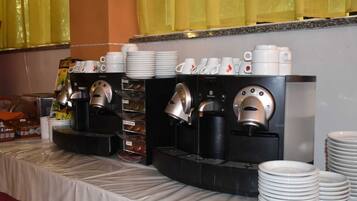 Ein reichhaltiges Buffet mit verschiedenen Kaffeemaschinen und Stapeln weißer Teller.