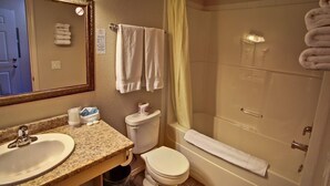 A bathroom with a sink, toilet, and bathtub. - Lake Country Inn (Lake Country)