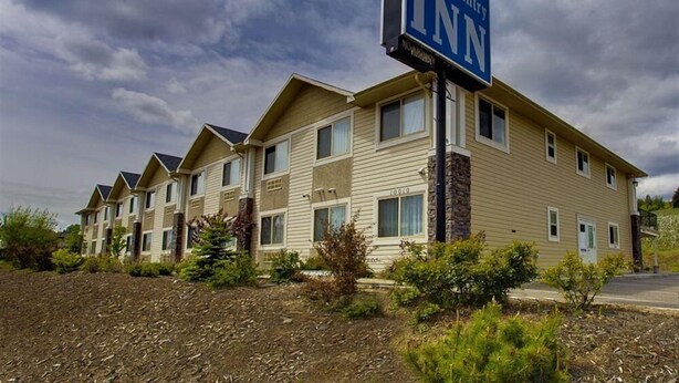 A Lake Country Inn building with multiple two-story units, a signboard, and a landscaped front yard. - Lake Country Inn (Lake Country)