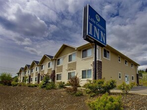 A Lake Country Inn building with multiple two-story units, a signboard, and a landscaped front yard. - Lake Country Inn (Lake Country)