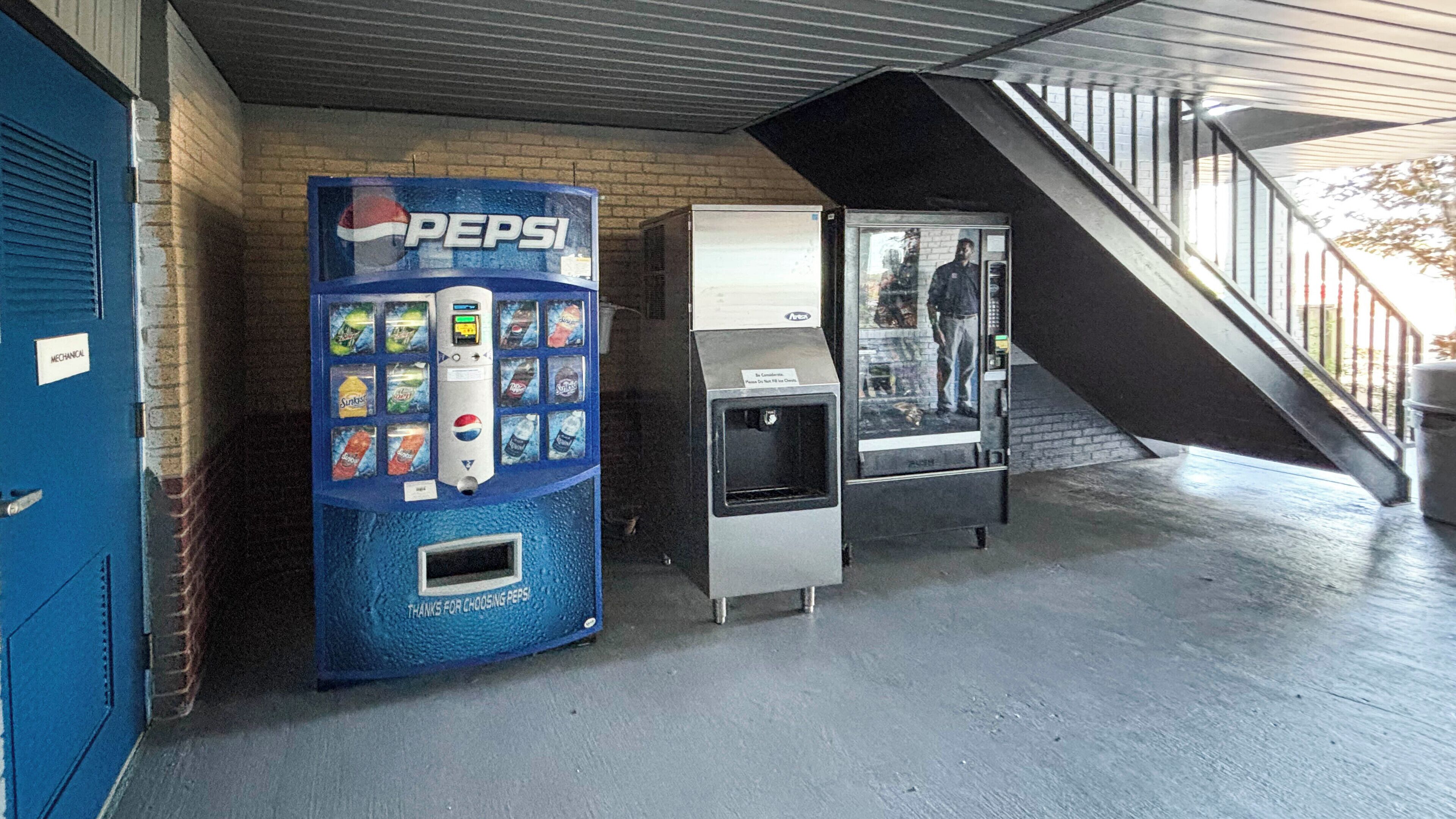 A vending machine with a Pepsi logo, a water dispenser, and a refrigerator.
