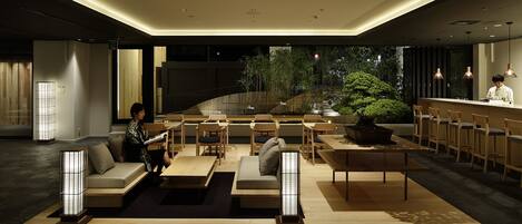 A modern interior with a bar area, seating, and a view of the outdoors.
