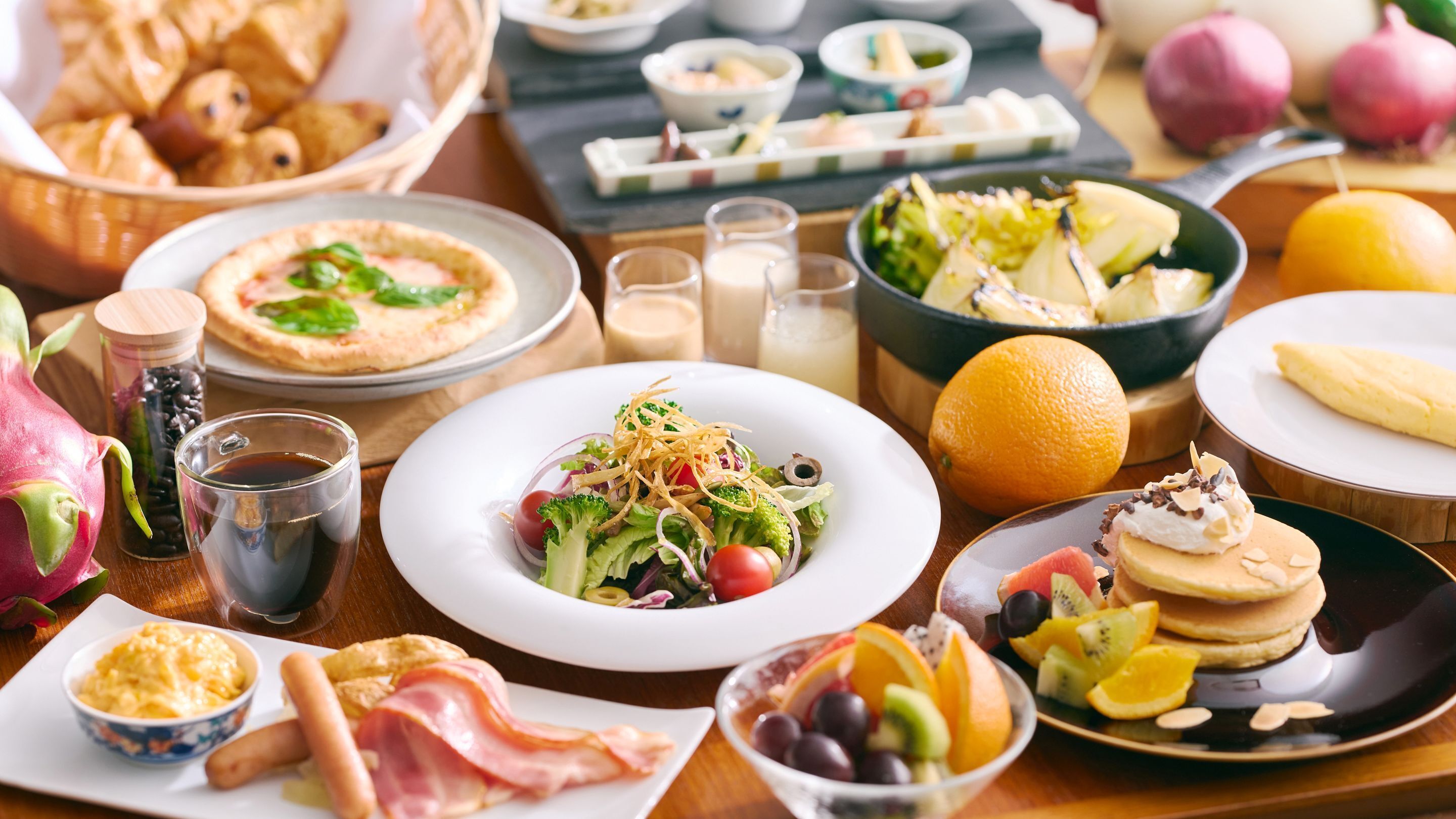 A breakfast buffet with various dishes, including a salad, fruit, and pastries.