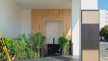 L’entrée d’un hôtel, dotée d’un design moderne, avec une enseigne et un escalier menant à l’intérieur.