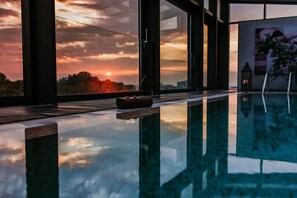 Una piscina techada, sillones reclinables de piscina