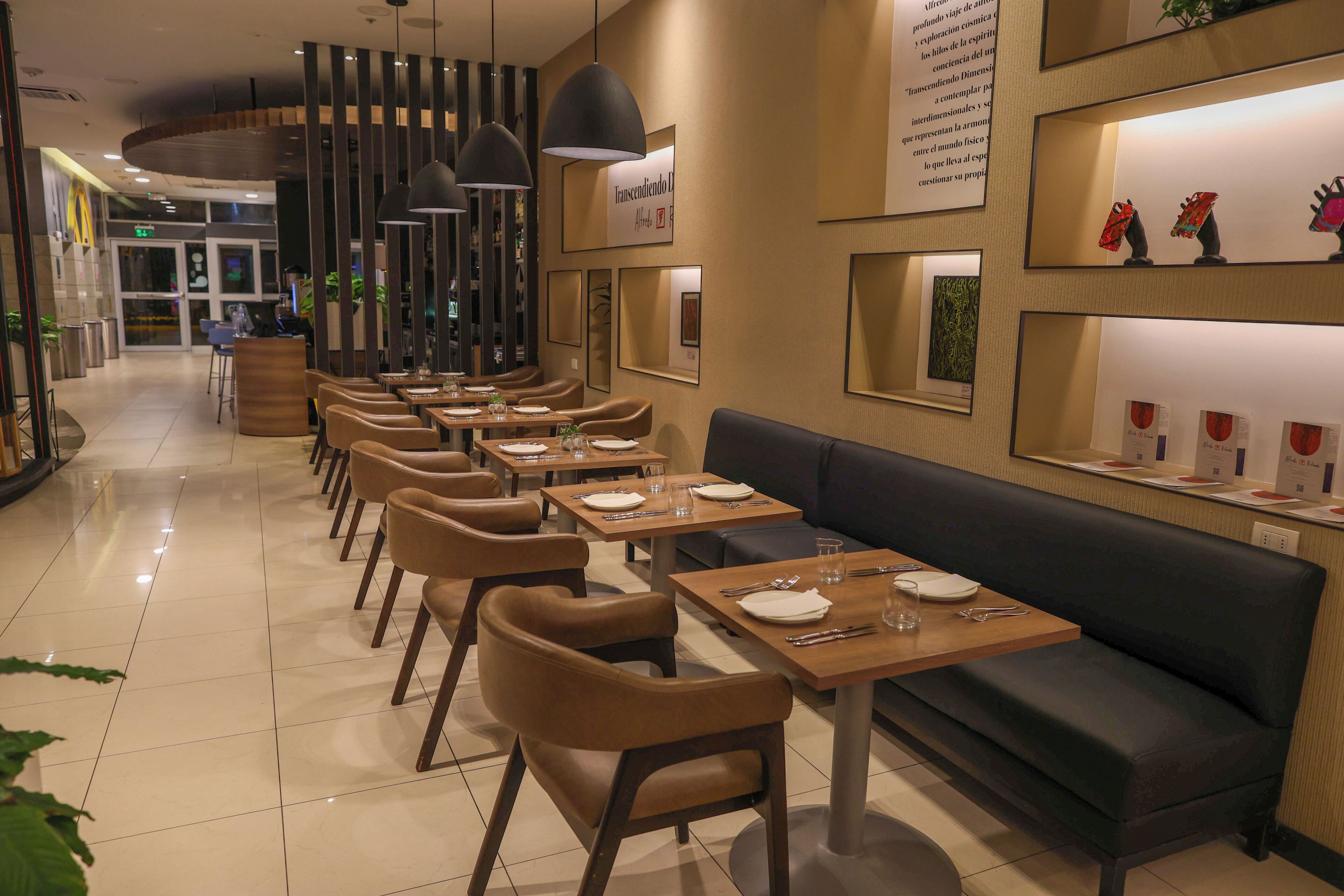 Un restaurante con una barra larga, cabinas y diferentes opciones de asientos.