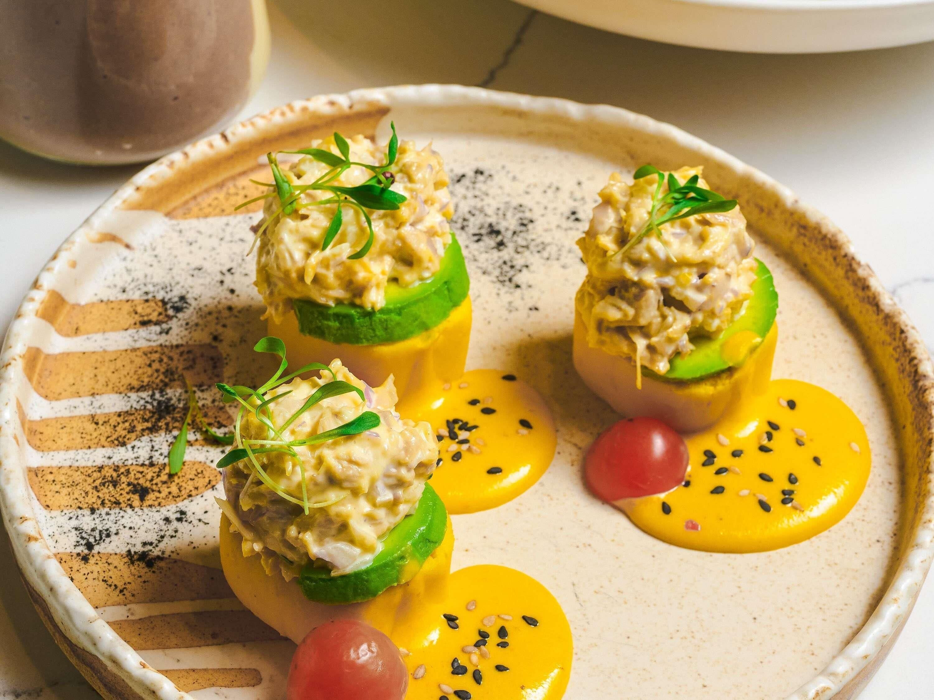 A plate with food items, including a stuffed vegetable and a dollop of sauce.