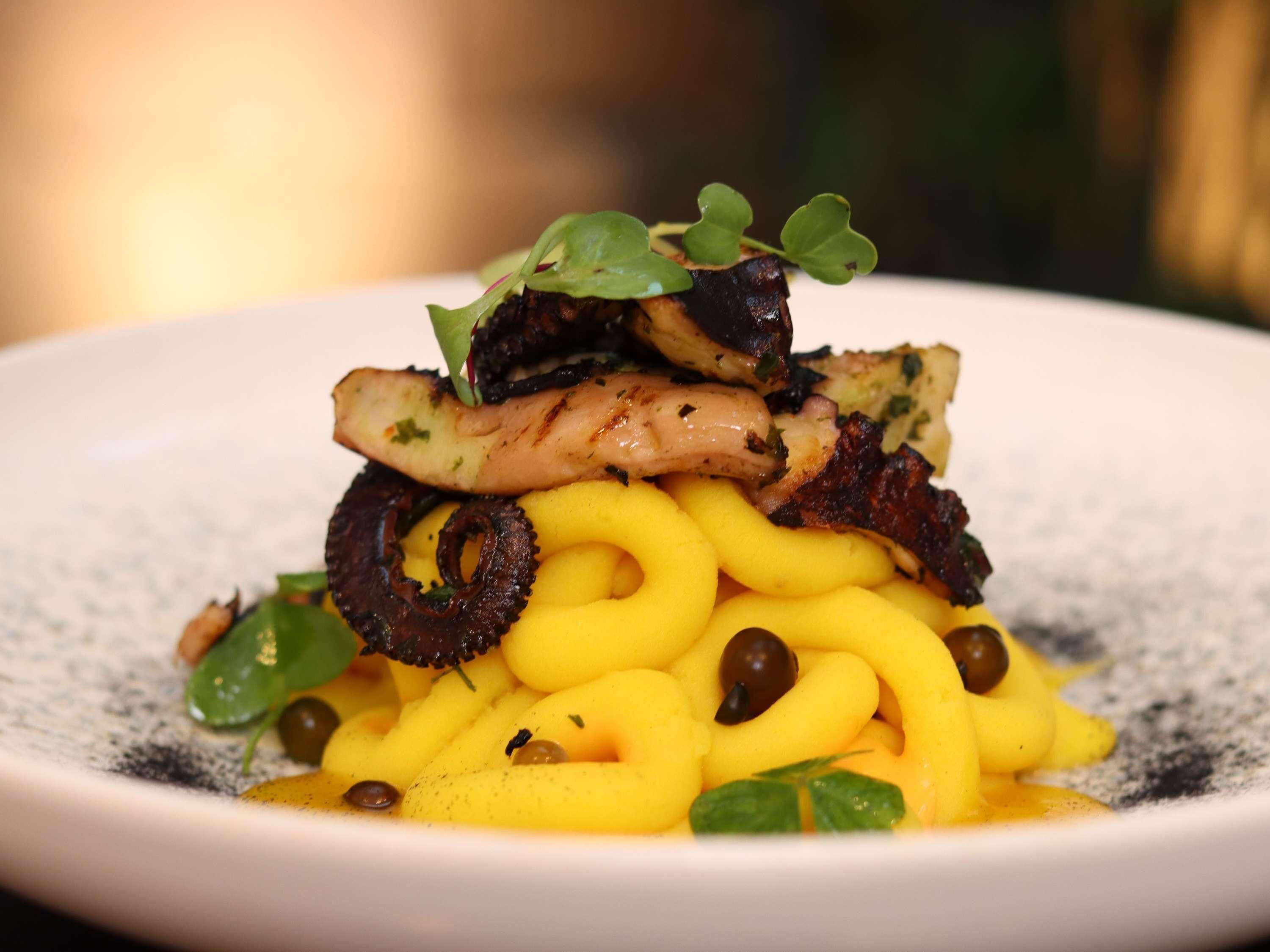 A plate of food with pasta, mushrooms, and greens.