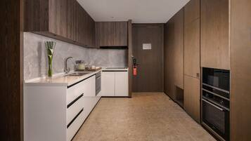 A modern kitchen with wooden cabinets, a marble countertop, and stainless steel appliances.