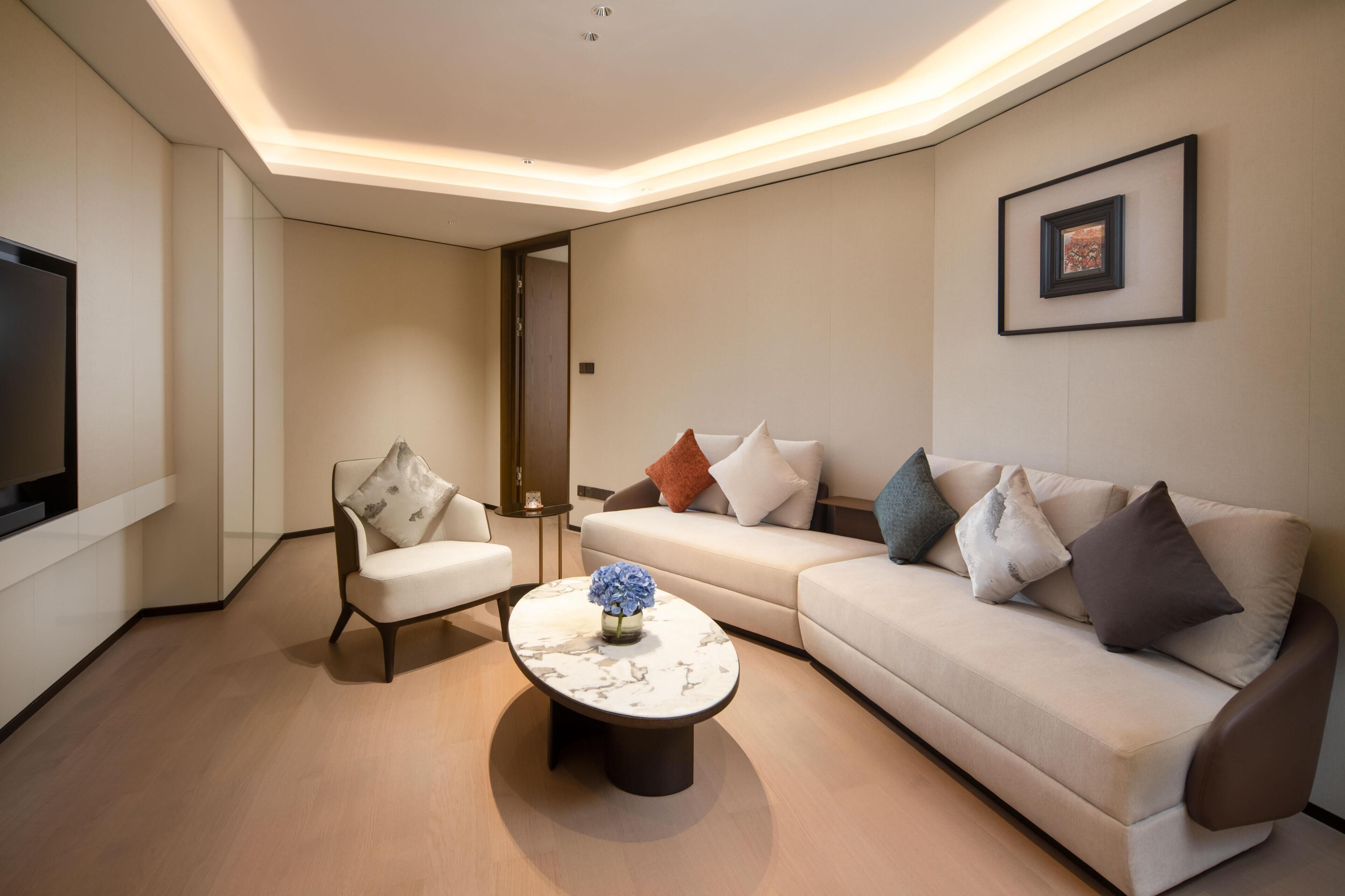 Suite junior, 1 cama de matrimonio grande | Zona de estar | Televisión LED de 55 pulgadas con canales por cable, una oficina