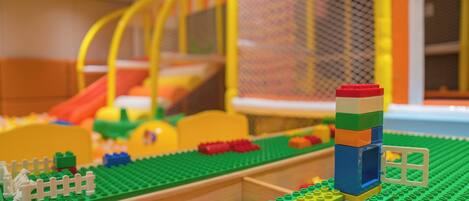 Vista detallada de un área de juegos LEGO con varias estructuras y un tobogán.