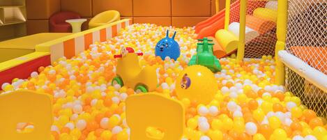 A play area with a ball pit, slides, and soft play furniture.