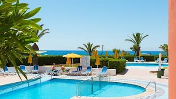 Piscine extérieure, parasols de plage, chaises longues