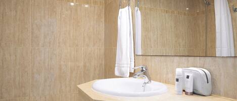 A bathroom with a sink, mirror, shower, and towel rack.