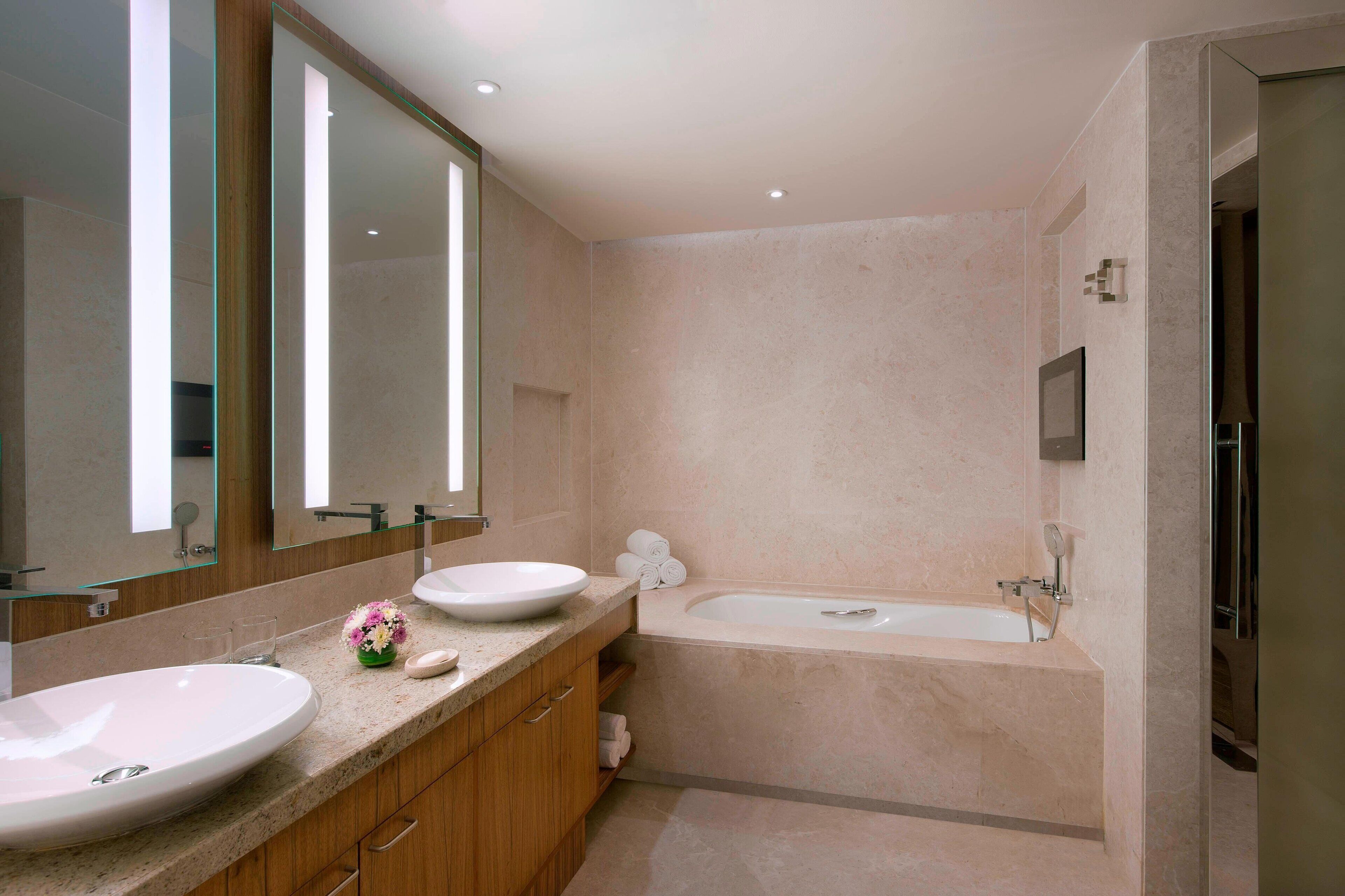 Un baño moderno con un lavamanos grande, una bañera y un espejo.