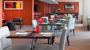Un comedor moderno con paneles de madera, varias mesas y sillas.