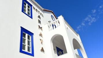 Un edificio blanco con detalles azules y un reloj.