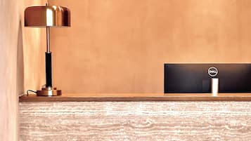 A reception desk with a modern lamp and a wooden textured floor.