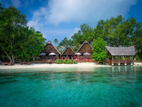 Un complexe hôtelier en bord de mer, doté de bungalows aux toits de chaume, d’eaux turquoise cristallines et d’une végétation luxuriante.