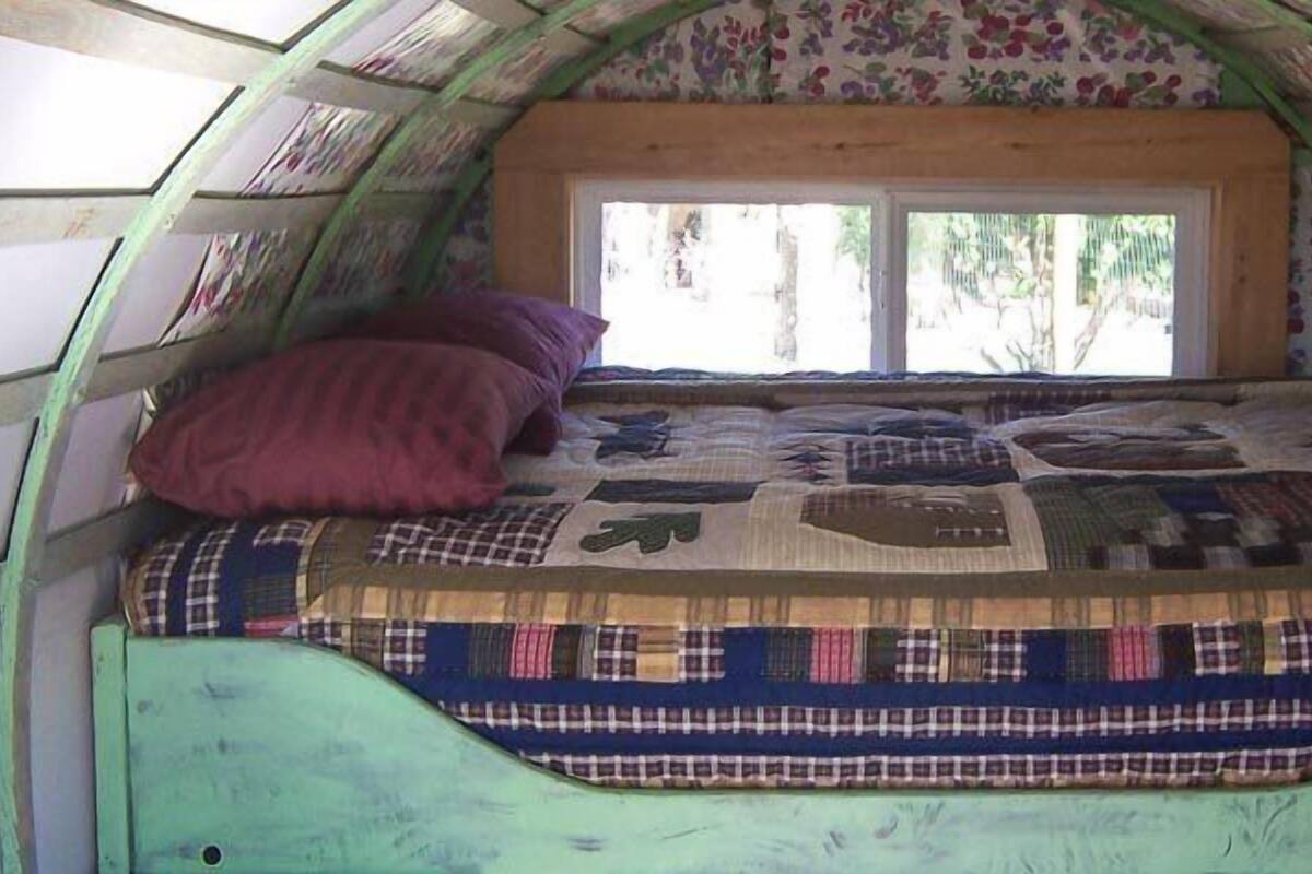 Um espaço reservado e aconchegante para dormir, com uma cama, uma janela e um edredom acolchoado.