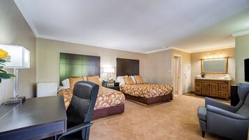 Una habitación de hotel con dos camas, un escritorio, una silla, un aparador y un espejo.