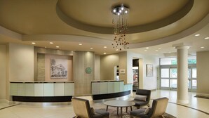 Una hall con una reception, un'area salotto e un'imponente colonna.
