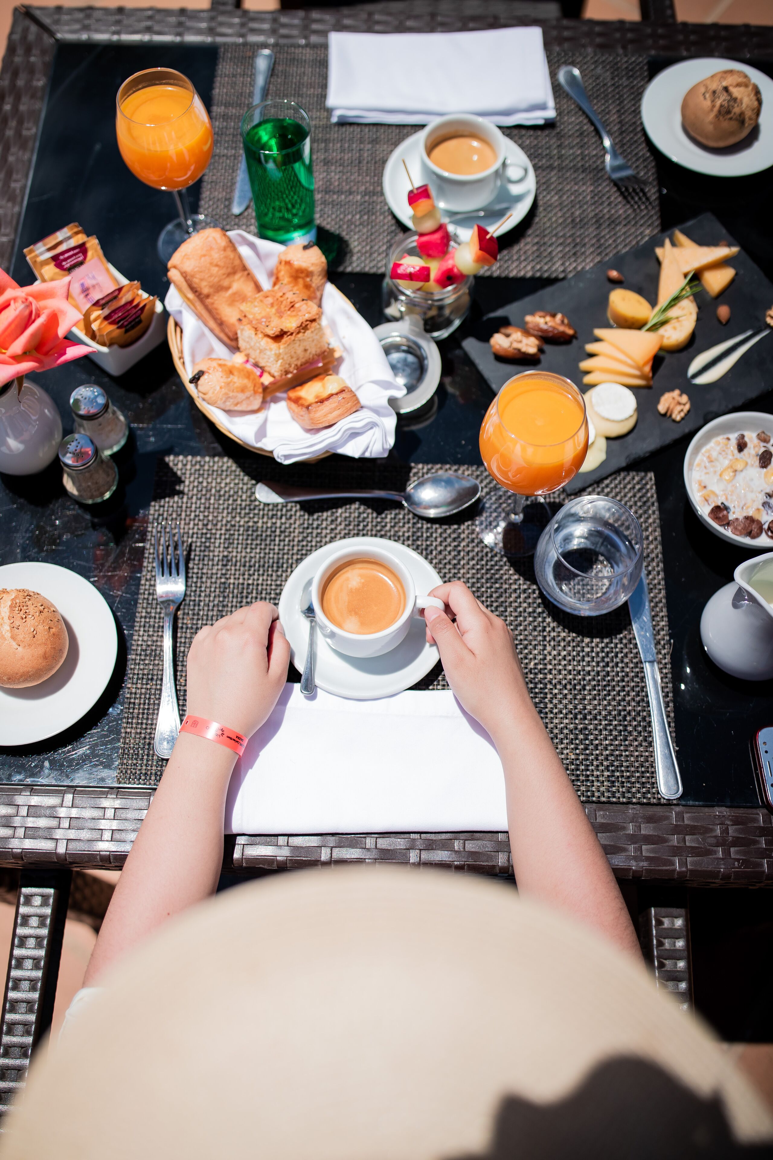 A breakfast table with various food items, including pastries, fruits, and beverages.