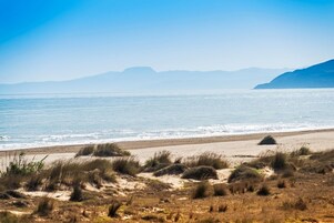 On the beach, white sand, sun loungers, beach umbrellas