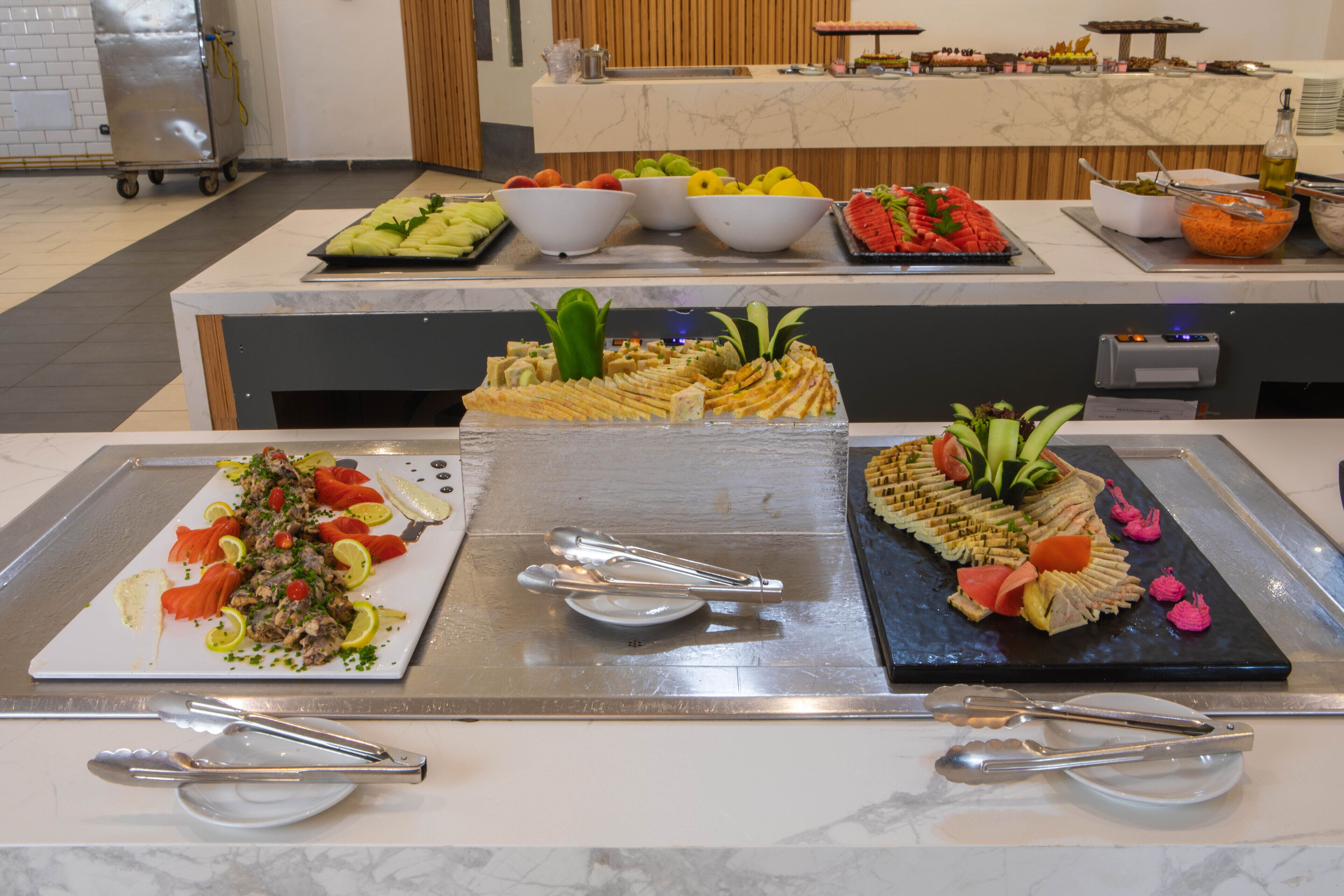 En buffé med ett varierat utbud av rätter, inklusive sallader, frukt och smårätter.