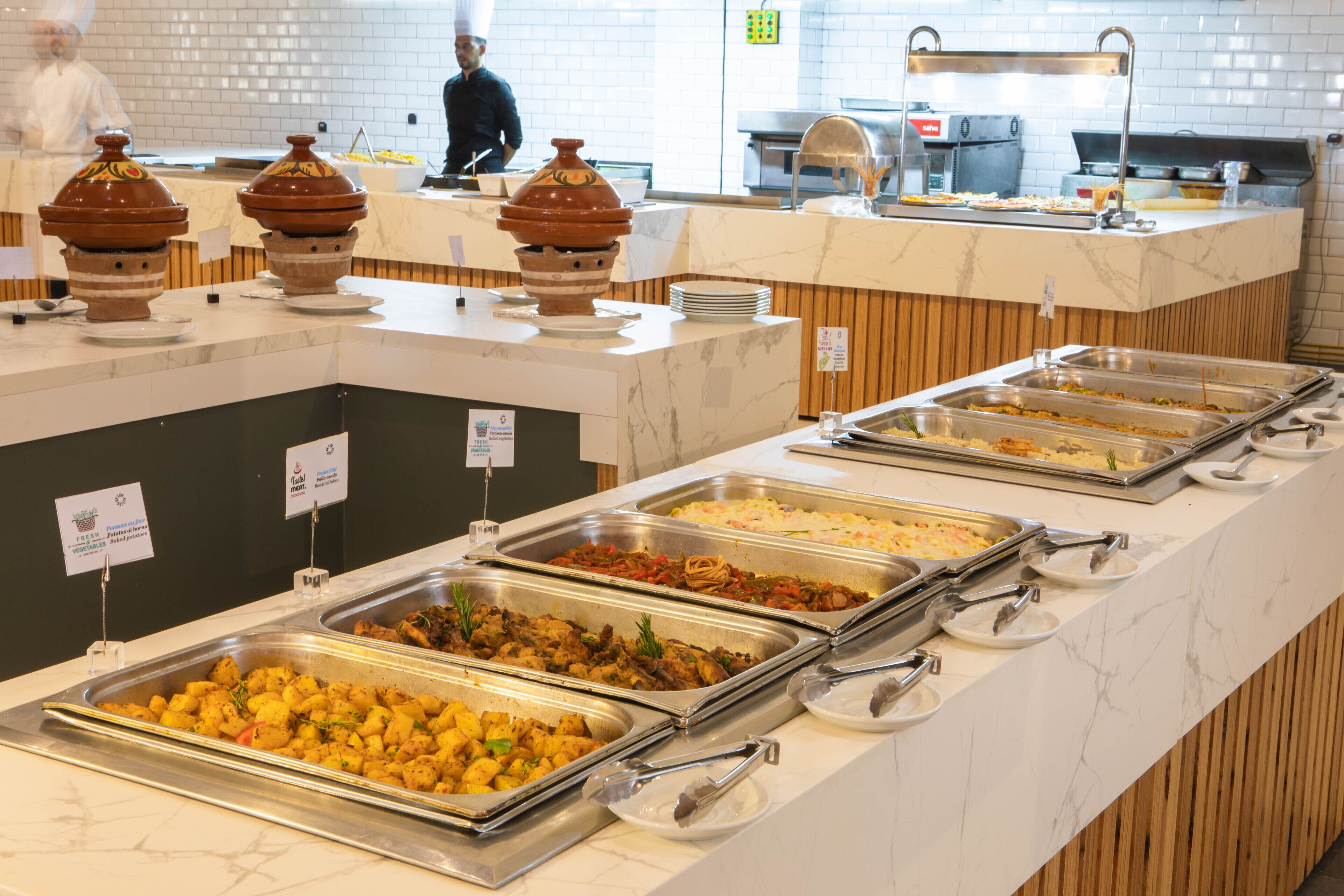A buffet with various food options, including salads, meats, and side dishes.