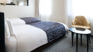 A hotel room with a double bed, a small round table, a chair, and a large mirror on the wall. - APA Hotel Ikebukuro Eki Kitaguchi (Tokyo)