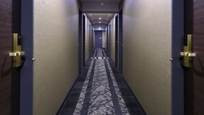 A hotel hallway with patterned carpet, doors with gold handles, and a ceiling light. - APA Hotel Ikebukuro Eki Kitaguchi (Tokyo)