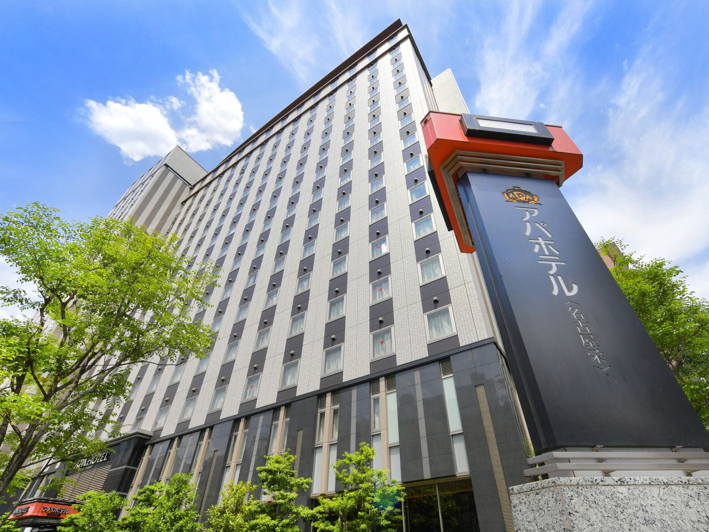 Un grand hôtel à l’architecture moderne, avec une façade imposante et une entrée remarquable, agrémentée d’une enseigne noire et dorée.