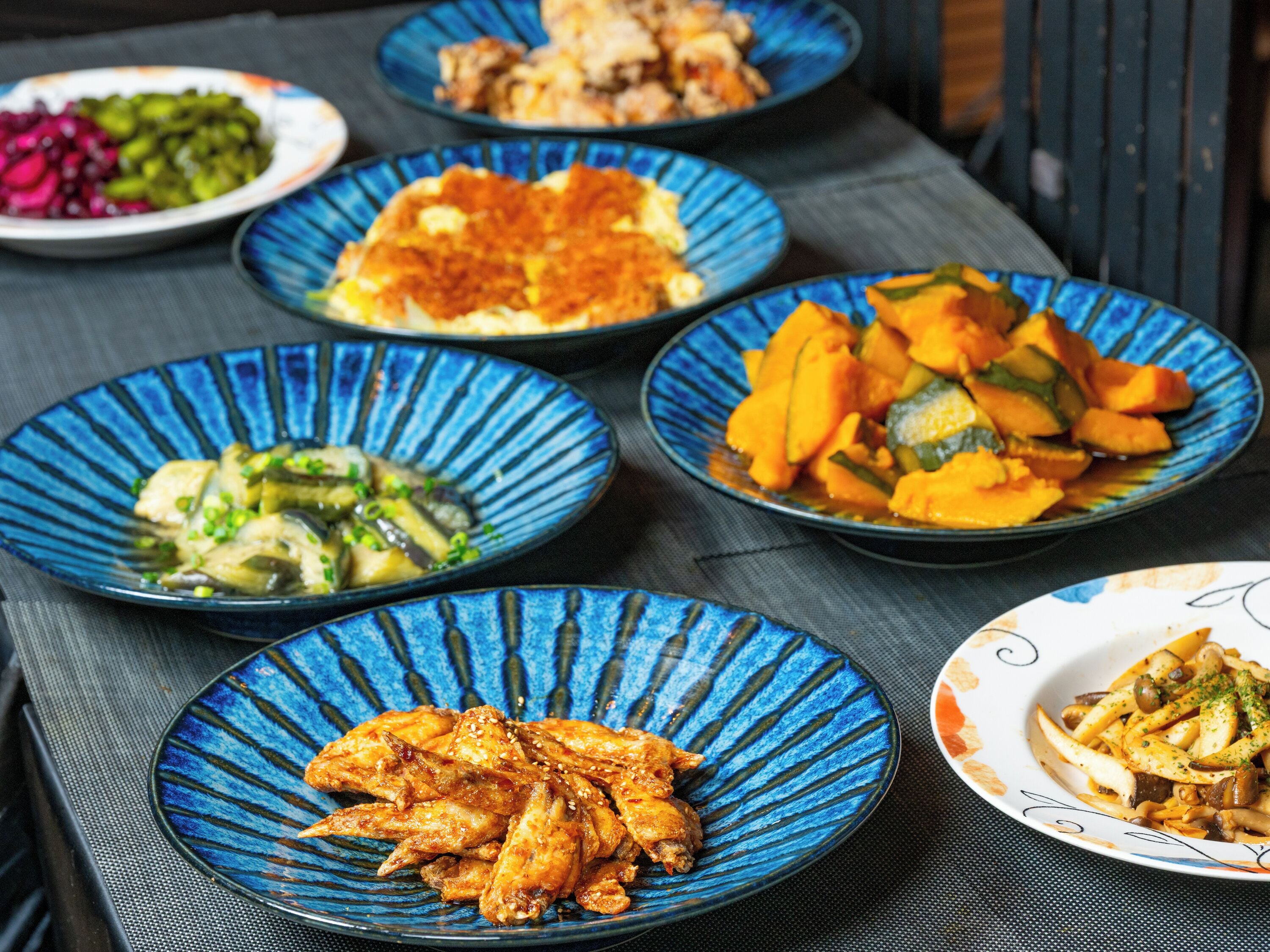 A table with various dishes on blue plates.